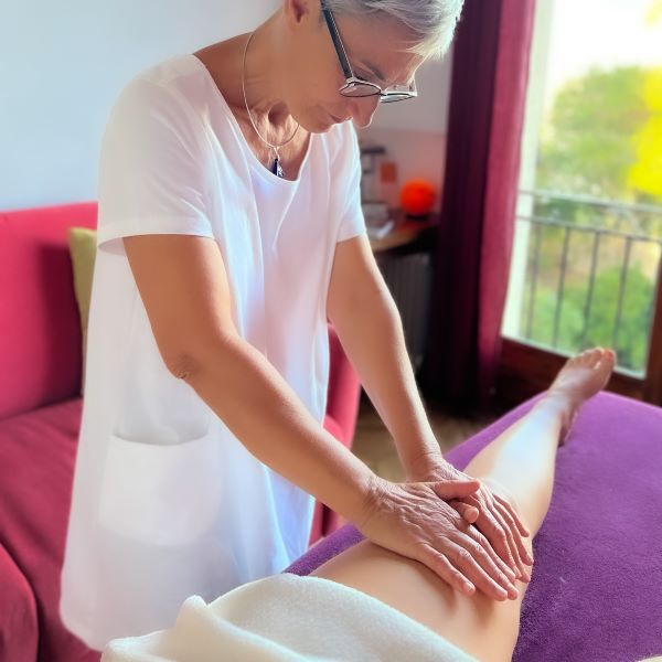 Drainage lymphatique manuel des jambes selon la méthode Vodder pour illustrer le soin Rituel Légèreté. Les mains de la praticienne sont posées sur la cuisse gauche de la cliente qui est allongée sur une table de massage.